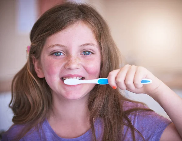 Keeping my teeth in tip-top shape. a little girl brushing her teeth