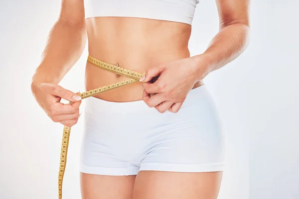 減量の食事療法とトレーニングの結果 ワークアウトの進捗状況や体の目標を追跡するためのテープ対策を持つ女性 健康的なライフスタイル 動機と健康的なフィットネスモデルは 胃の腰を測定 — ストック写真