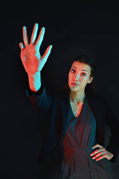 Work is a four letter word. Portrait of a young businesswoman showing a number with her fingers against a dark background