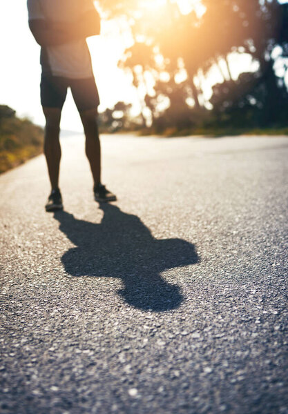 Be fierce and face your own shadow. a runner standing on the road