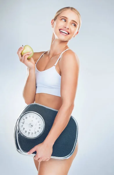 体の健康 セルフケアと自然体重減少のためのスケールを持つアップル 食事や女性 健康食品 栄養ライフスタイル 健康運動トレーニングを食べる灰色のスタジオでの脂肪トレーニングの背景 — ストック写真