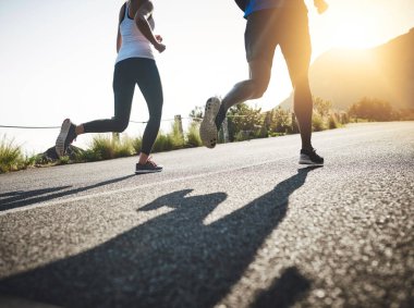 Eğer vücudun varsa, sporcusun demektir. İki tanınmayan insan asfalt yolda koşuyor.