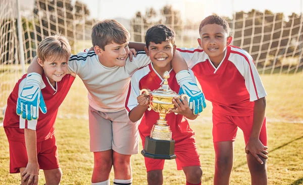 Football, teamwork and sports with trophy and children at goal post for winner, happy and fitness. Exercise, success and award with soccer player celebration for workout, training and champion.