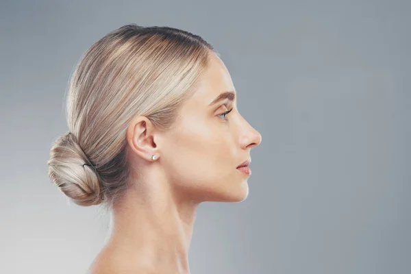 Skincare, profile and side face of a woman for dermatology, wellness and natural beauty against a grey mockup studio background. Advertising, marketing and model with cosmetic health and space.