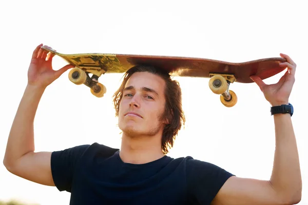 私は覚えている限りずっとスケートをしていた スケートボードを持って立っている若い男の肖像画 — ストック写真