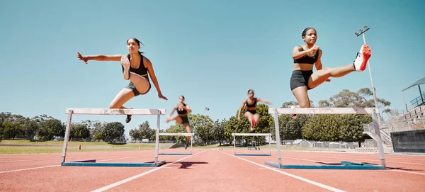 Woman, jumping and hurdles in competitive sports training, exercise or athletics on the stadium track. Women in sport fitness competition for hurdle jump, running and fast cardio exercising outside.