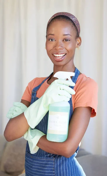 Black woman, spring cleaning service and spray bottle for housekeeping, sanitation and disinfection of dirt, bacteria and dust in home. Portrait happy maid, hospitality cleaner and house maintenance.