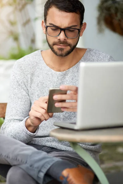 stock image Maximum productivity thanks to free wifi. a handsome young man using his phone and laptop at an outdoor cafe