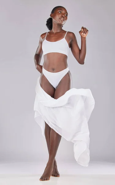Black woman, underwear model and smile in fashion studio, beauty or body  care by white background. Happy african woman, lingerie or bikini body,  cosmetics or skin wellness with confidence and proud