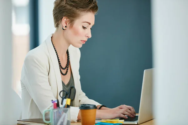 stock image Keeping up the pace in business. a young businesswoman working on a laptop in an office