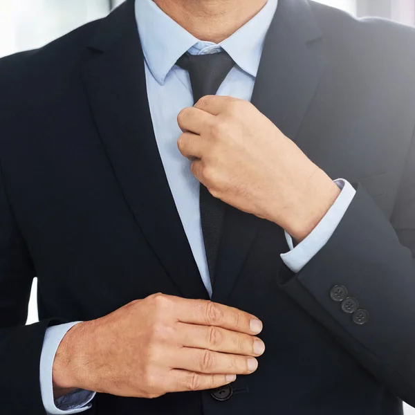安全で成功しているように見えます オフィスに立っている間に彼のネクタイをまっすぐに成熟したビジネスマンの閉鎖ショット — ストック写真