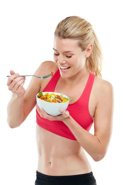 何も健康的な感じほどよく見えません サラダを食べながら運動中の若い女性のスタジオショット — ストック写真