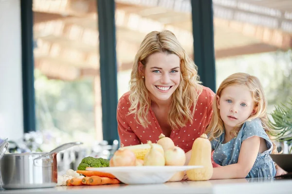 私たちは料理に健康的で健全な食材のみを使用しています 家で一緒に食事をする母親と娘の肖像画 — ストック写真