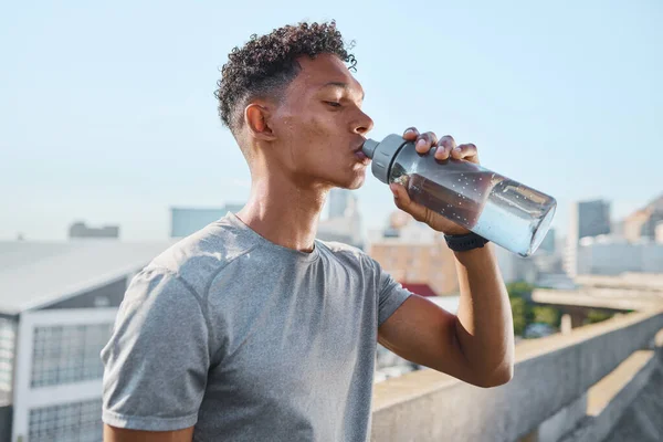 stock image Fitness, exercise and man drinking water in city after running, training or cardio workout. Health, wellness and hydration of sports male from India resting or on break after marathon or sprinting