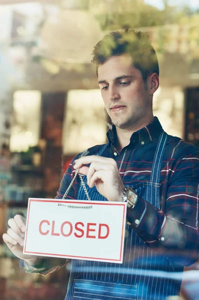 stock image Time to close up for the day. Closeup shot of a young man hanging up a closed sign in a shop window