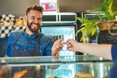 Müşteriler her zaman değerli bir hizmet için uğrarlar. Bir garsonun müşteriden kredi kartı ödemesini kabul etmesi.