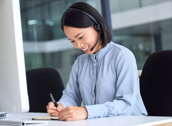 Call center, customer service and writing with an asian woman consultant working in a telemarketing office. Contact us, computer and receptionist with a female assistant taking notes for sales.