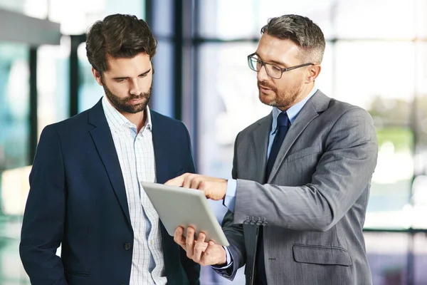 stock image Technology has driven a great amount of change to business. two businessmen working together on a digital tablet in an office