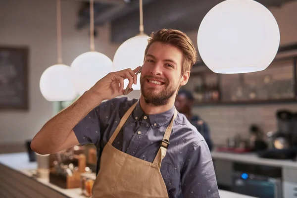 stock image Youre most welcome to come check my place out. a friendly barista talking on his cellphone