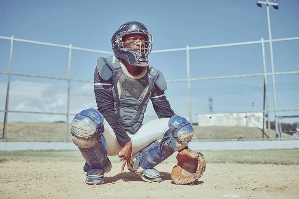 Baseball, fitness and catcher on a baseball field training for a sports game in an outdoor exercise workout in summer. Focus, wellness and healthy black man in safety gear with a secret hand gesture.