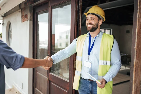 Construction, architect and handshake deal at building for professional contract, trust and welcome. Architecture, house and renovation planning agreement with expert worker man on site