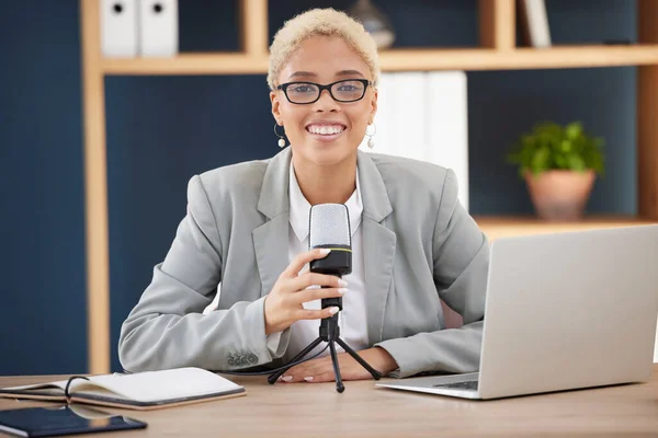 Podcast, radio or broadcast with a black woman working on a laptop in her office for live streaming or content. Influencer, microphone and studio with a female presenter broadcasting from work.