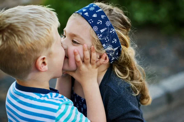 조금이라도 애정을 보이는 두려워하지 밖에서 동안작은 소녀가 남동생에게 키스를 — 스톡 사진