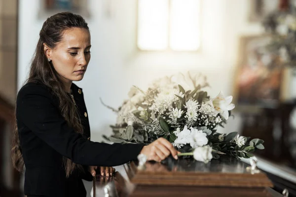 悲伤的女人 在失去亲人 家人或朋友后 在棺材上放着鲜花 死亡和年轻女子将玫瑰放在教堂的棺材里 沮丧和哀伤 — 图库照片