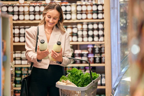 Woman, shopping and organic milk for diet, health or nutrition in store, supermarket or grocery shop. Happy, vegan girl and sale of product in retail, discount or promotion sales for wellness food.