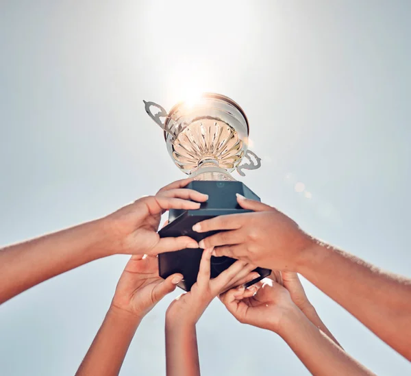 Women, hands or sports trophy in fitness success, workout game or exercise match on summer blue sky. Low angle, team and winner prize cup for school community, training health or wellness award goals.