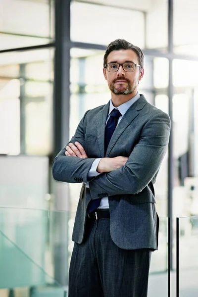 Success follows confidence. Portrait of a mature businessman standing with his arms folded in the office