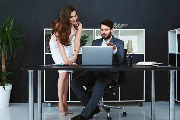 stock image We could use this research to improve our strategies. businesspeople working together on a laptop in a modern office
