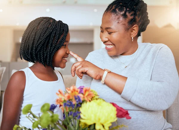 Love, mother and girl smile, happy and together for bonding, loving and happiness together. Mama, daughter and black family being playful, caring and quality time being cheerful in home with flowers