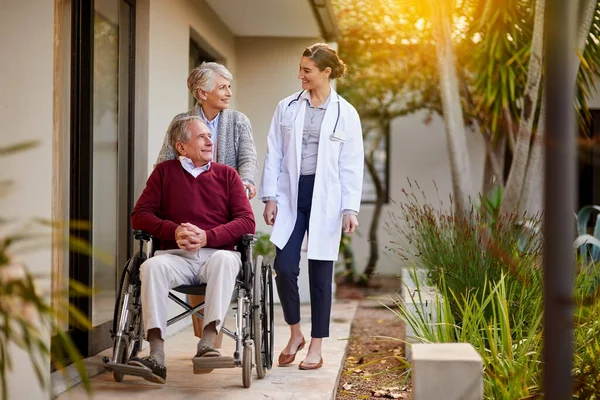 stock image Fresh air is beneficial to his recuperation. a senior couple and a nurse outside a nursing home