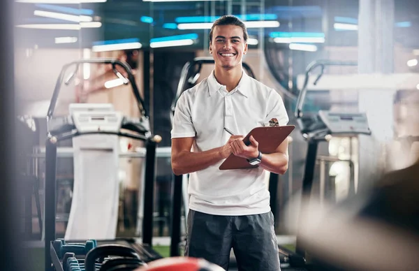 Gym, fitness and portrait of a personal trainer with a clipboard for a training consultation. Happy, smile and sports coach or athlete with a wellness, health and exercise checklist in workout center.