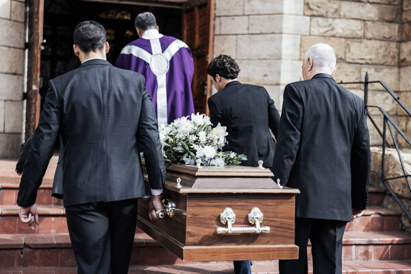 Смерть, похороны и держание гроба в церкви для скорби, утраты и с семьей вместе на ступеньках. Скорбящие, грустные и прихожане в трауре, грустные и с прощанием перед погребением и деревянный гроб
