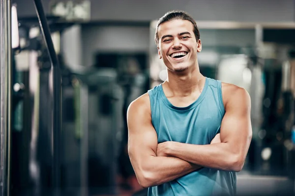 Fitness, gym and happy portrait of personal trainer man ready for workout coaching. Training, wellness and exercise coach confident with arms crossed at professional athlete health club