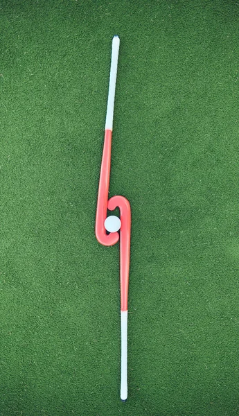 Hockey, sticks and ball on turf grass at a stadium for a sports match, exercise or training. Fitness, workout and sport equipment on outdoor field for championship game, practice or skill development.