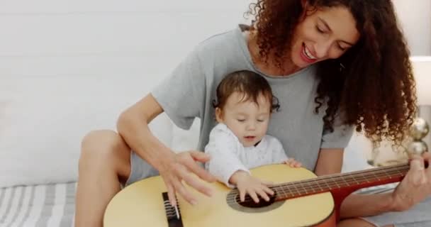 ギター 女性と赤ちゃんが演奏し 家庭での楽しさと発展のために学ぶことは愛情と陽気です 音楽のレッスンのための楽器と母 親と小さな赤ちゃんの女の子の結合 — ストック動画