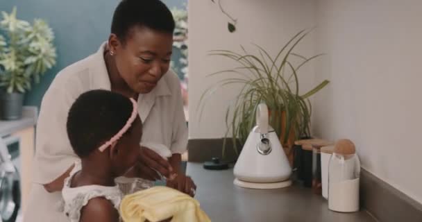 キッチンカウンターを掃除する布 母親と子供は 家の中で家事を手伝い 幸せになります アフリカのお母さんと女の子の子供衛生のための汚い家をきれいにするのを助けるために — ストック動画
