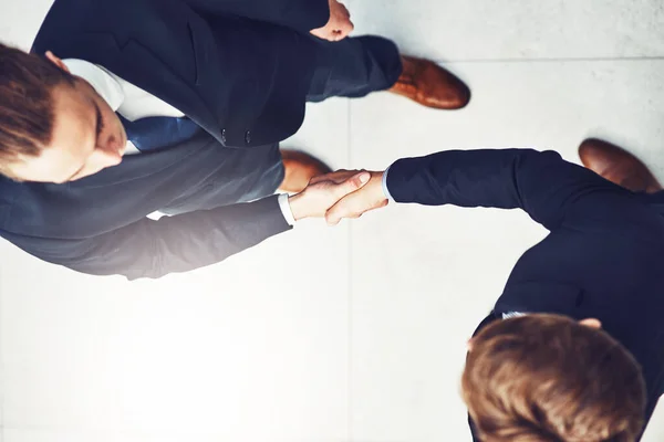 stock image It is my pleasure to welcome you to the company. High angle shot of two businesspeople shaking hands in an office