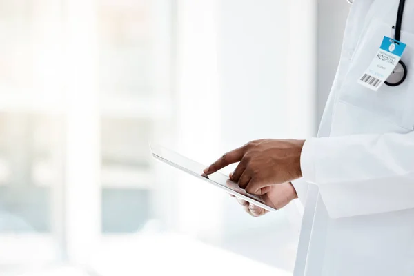 Doctor, hands and tablet in healthcare research, diagnosis or prescription for medical results at the hospital. Hands of professional GP working on touchscreen for health telecommunication at clinic.