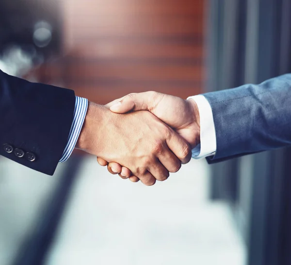 stock image Striking a deal. two unrecognizable businesspeople shaking hands in a corporate office