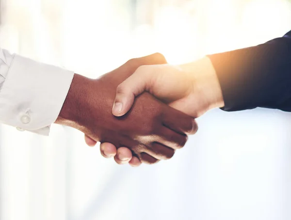 stock image The start of a new partnership. Closeup shot of two unidentifiable businesspeople shaking hands in an office