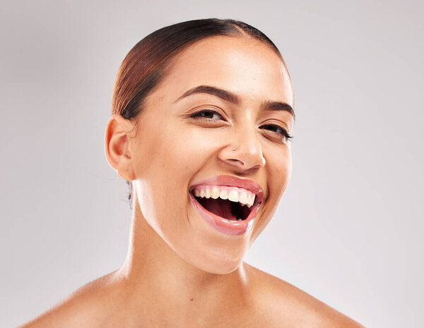 Woman, face and smile with teeth for dental care, hygiene or skincare against grey studio background. Portrait of happy female smiling in satisfaction for oral cosmetics, mouth or gum care treatment.