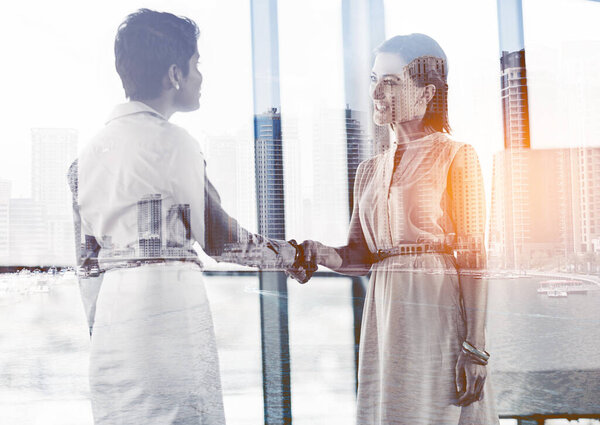 Moving up the ladder of success. Multiple exposure shot of two businesswomen shaking hands superimposed on a cityscape