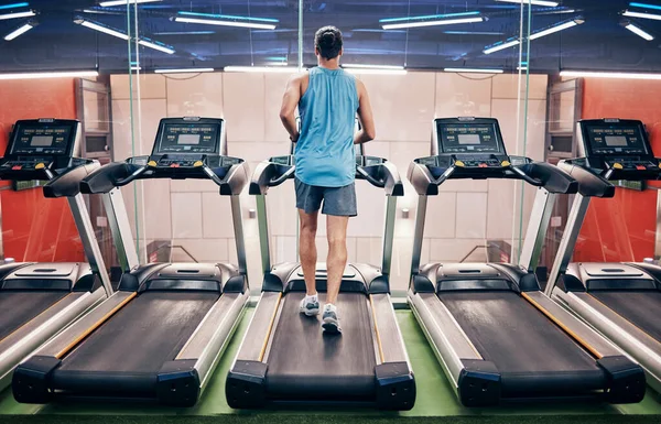 男人和在健身房跑步机上跑步 进行健康的有氧运动 锻炼或减肥锻炼 积极参加体育运动的男性跑步者在健身俱乐部用固定设备进行训练或锻炼 — 图库照片