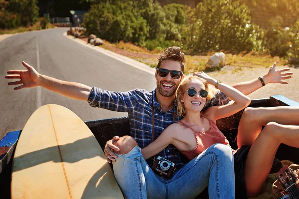 幸せを感じる場所まで車でお越しください 若いカップルがピックアップトラックの後ろでリラックスしながら — ストック写真