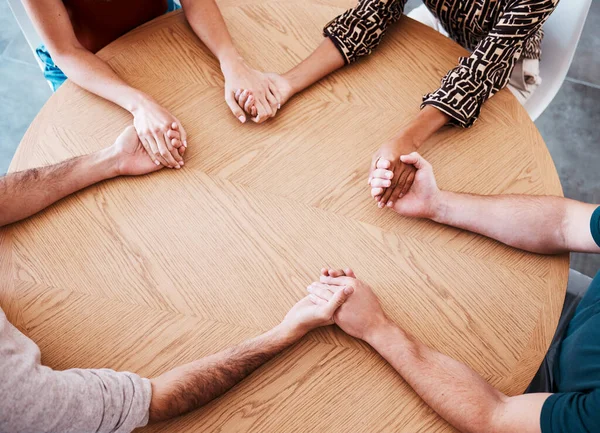 Business people holding hands in therapy group, team building or staff support with diversity, empathy and solidarity. Corporate circle hand holding on table above for prayer, trust and community.