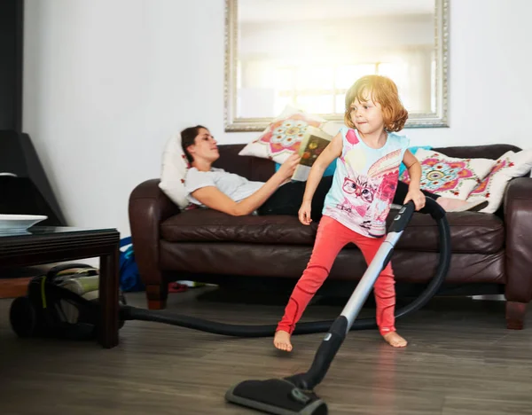 彼女はお母さんに休みを与える 母親がソファに横になり娘が床を掃除している間 — ストック写真